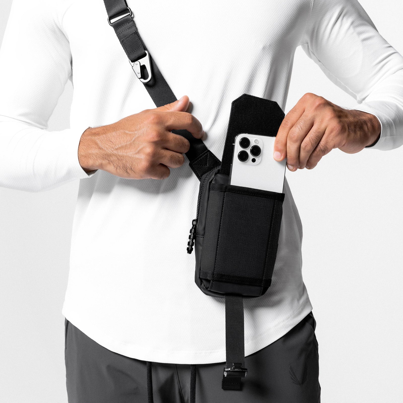Waterproof phone holster bag in black, worn as crossbody sling with smartphone displayed