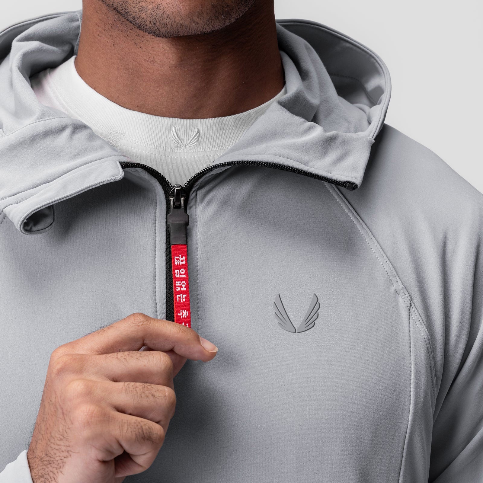 Training Hoodie in slate grey worn by model, front view with hand on zipper