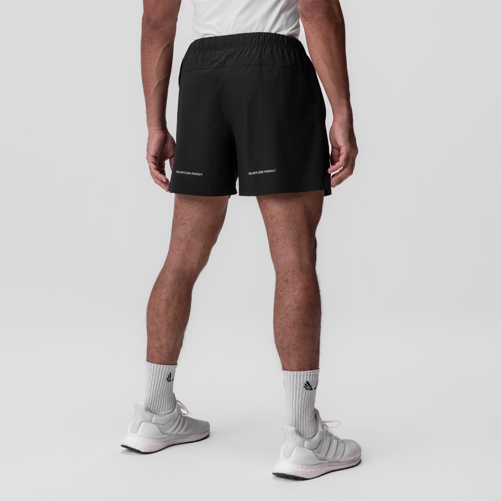 Ripstop 6" Perforated Short in black, worn by model from behind, styled with white socks and grey sneakers