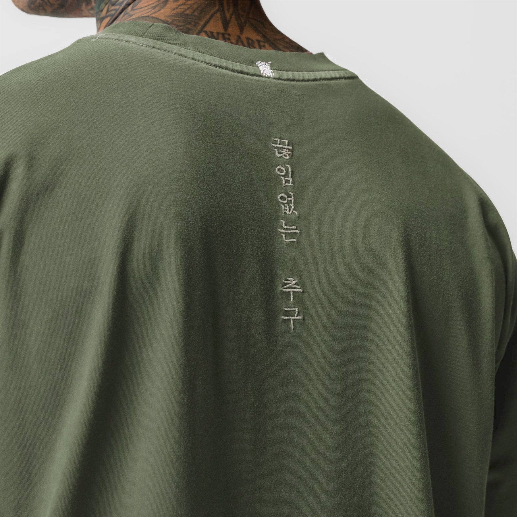 Tech Essential Relaxed Long Sleeve in Faded Olive, back view on model with vertical text detail