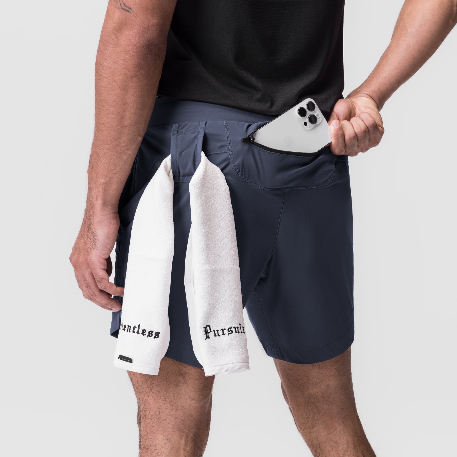 Tetra-Lite 7" Linerless Short in navy worn with white towel, front pocket detail