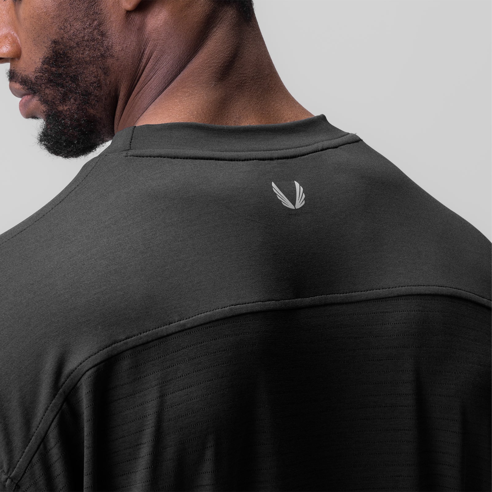 3D-Lite® 2.0 3/4-sleeve oversized tee in black, worn by model showing back view with logo