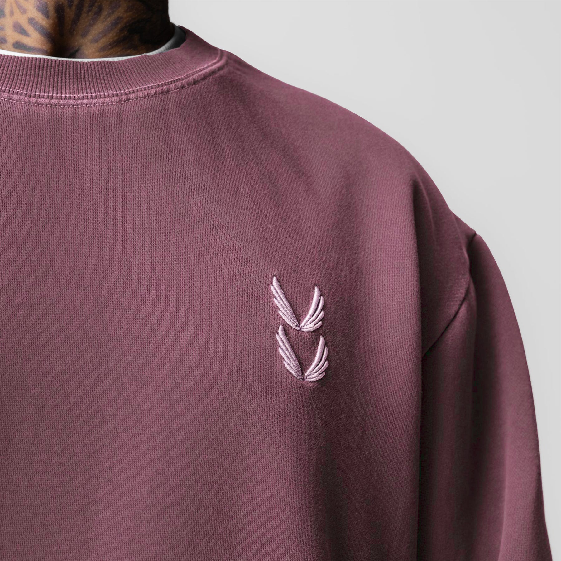Tech Essential Distressed Crewneck in faded crimson worn by model, chest detail view