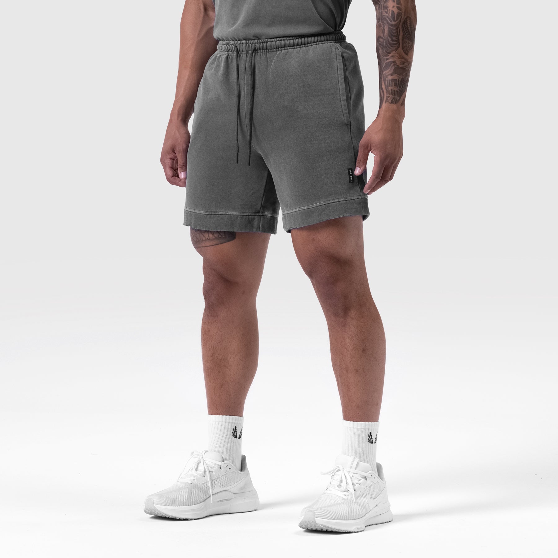 Tech Essential Sweat Short in Faded Grey, worn with white sneakers and white socks, front view on model