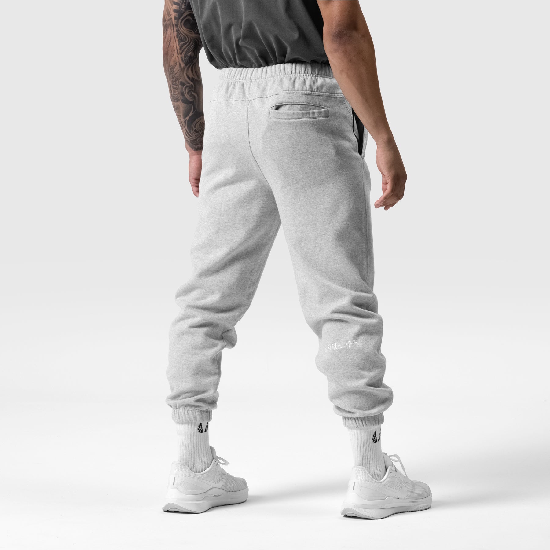 Tech Essential Sweats in Heather Grey worn by model, back view showing jogger fit and cuffed ankles