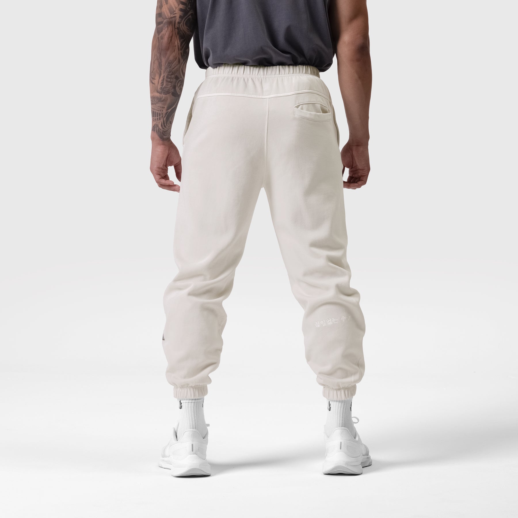 Tech Essential Sweats in faded stone, back view on model wearing black tank and white socks
