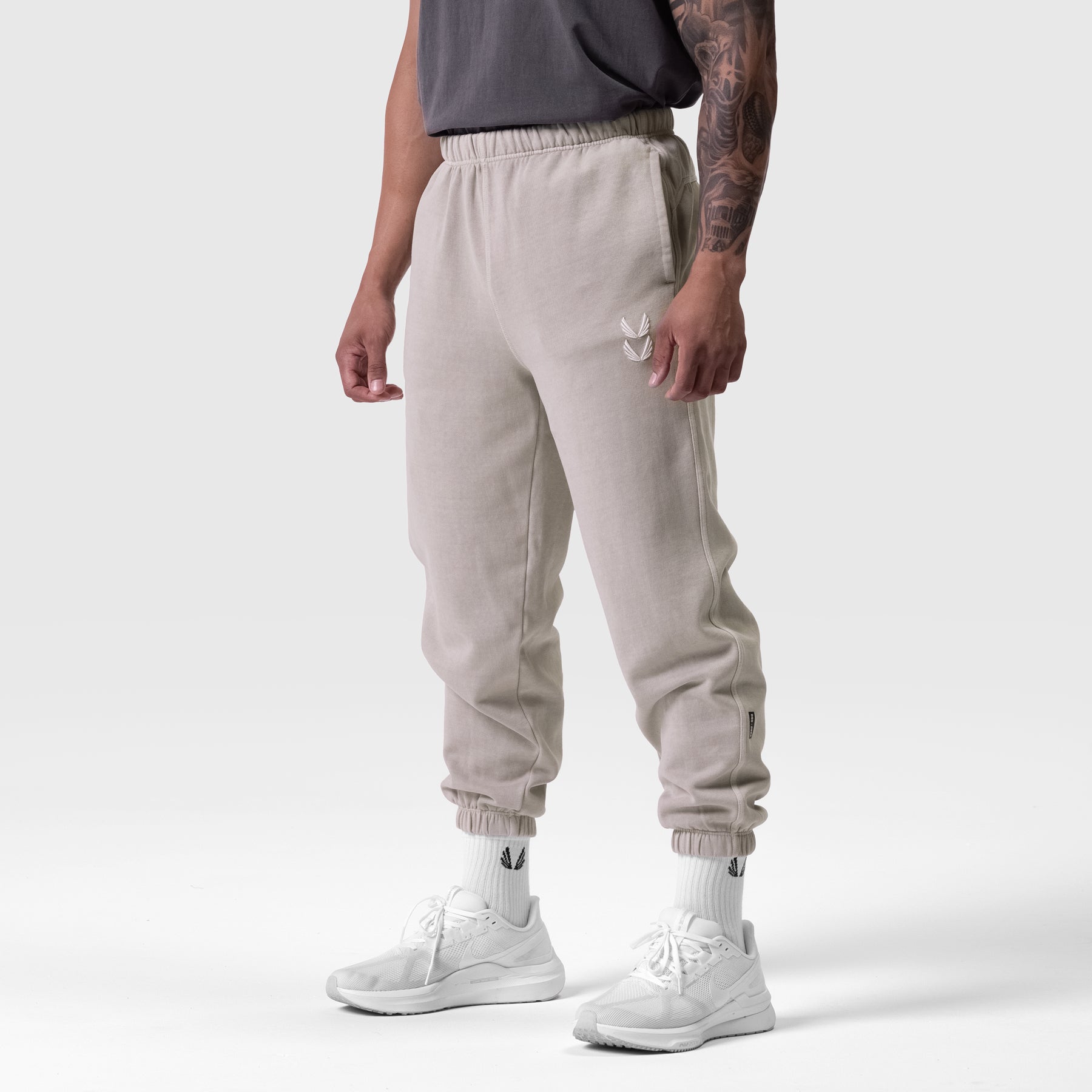 Tech Essential Sweats in faded chai worn by model, side view with white sneakers