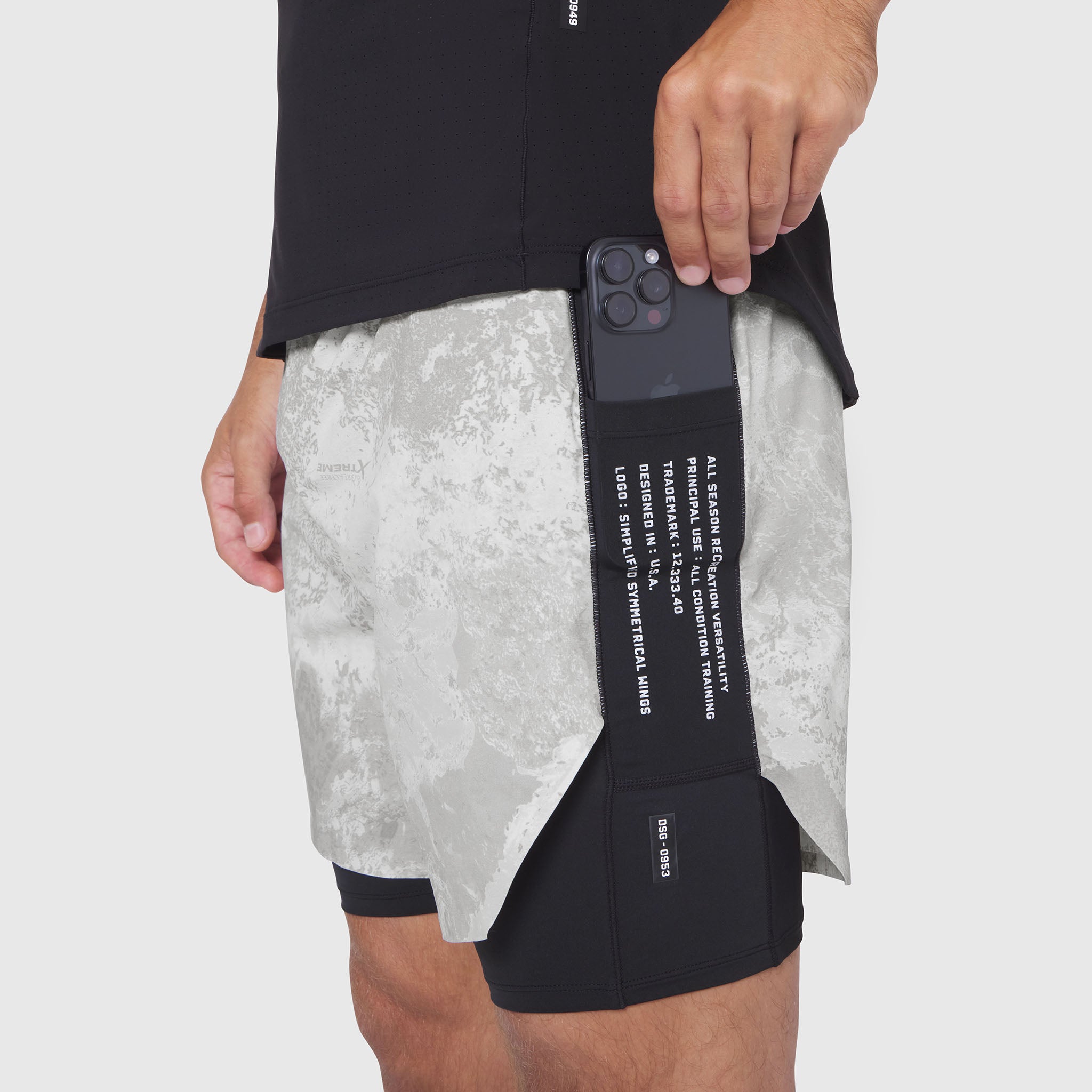 Aerotex Hybrid Liner Short in black with white camo, model holding phone in pocket