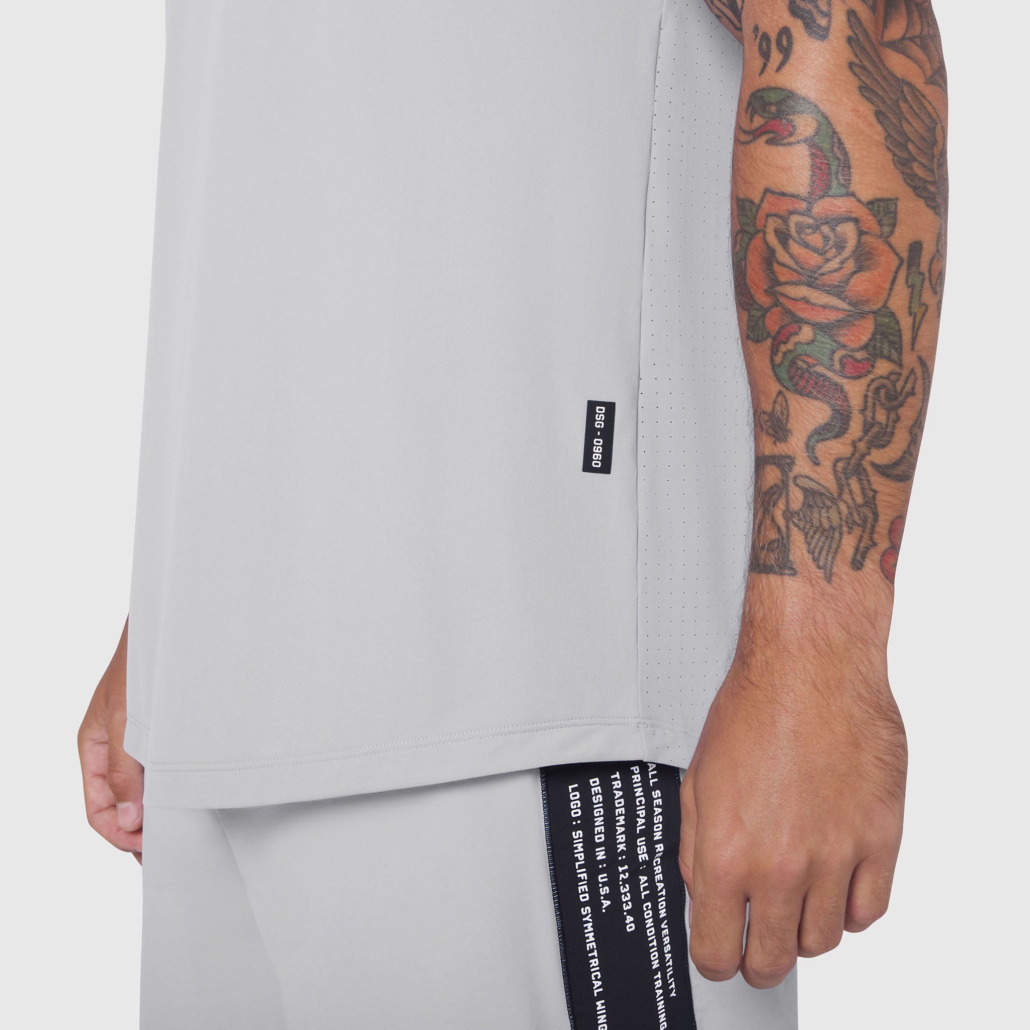 Laser-Vent™ Tank Top in white, worn by model showing side view with tattooed arm visible