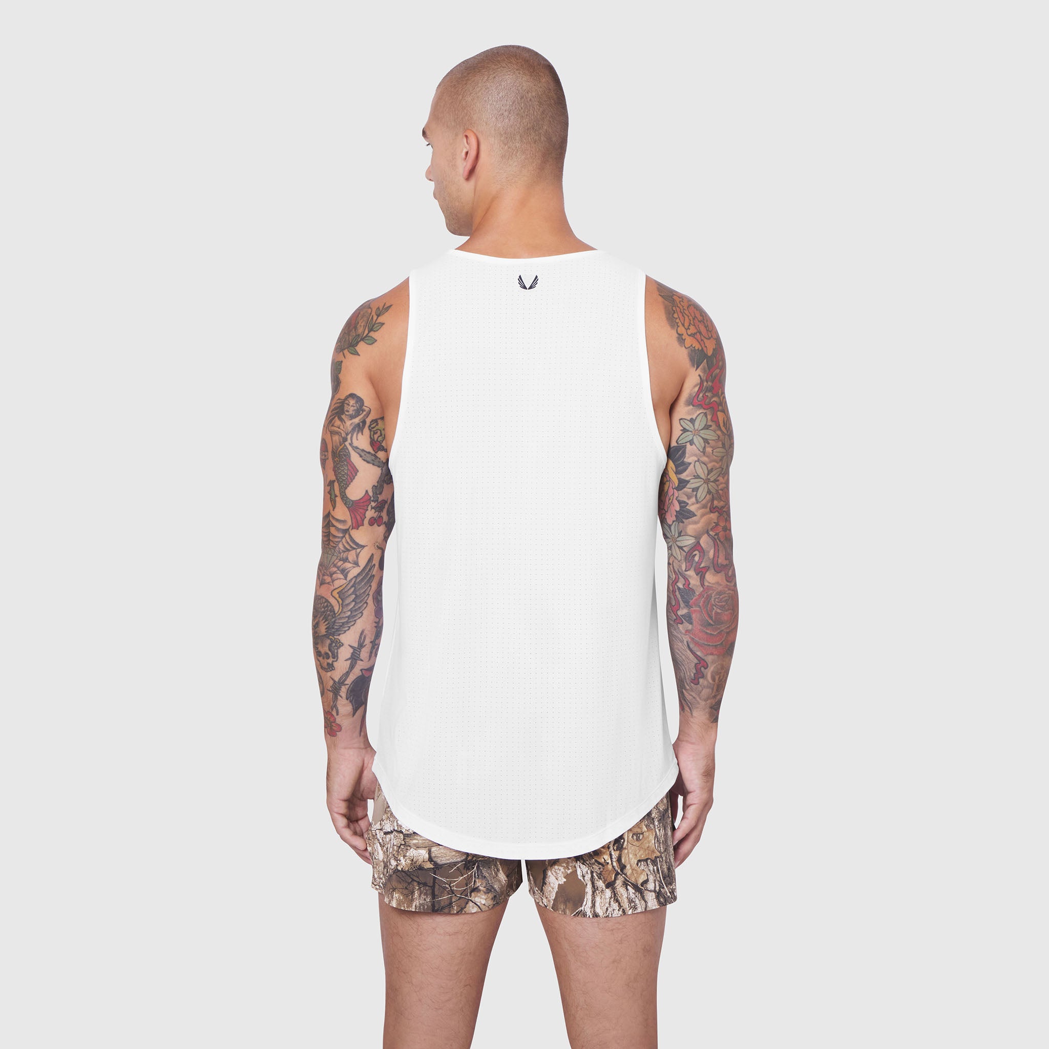 White Laser-Vent Tank Top worn by model, back view, with camouflage shorts
