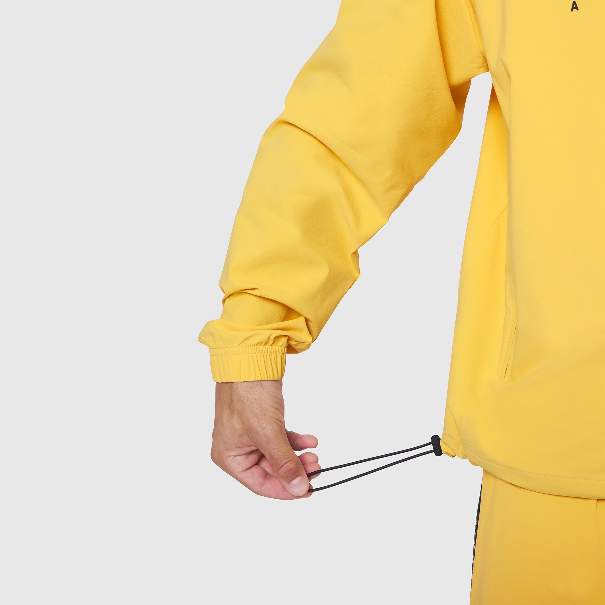 Aerotex Quarter-Zip Jacket in amber yellow, worn by model showing sleeve detail and drawcord