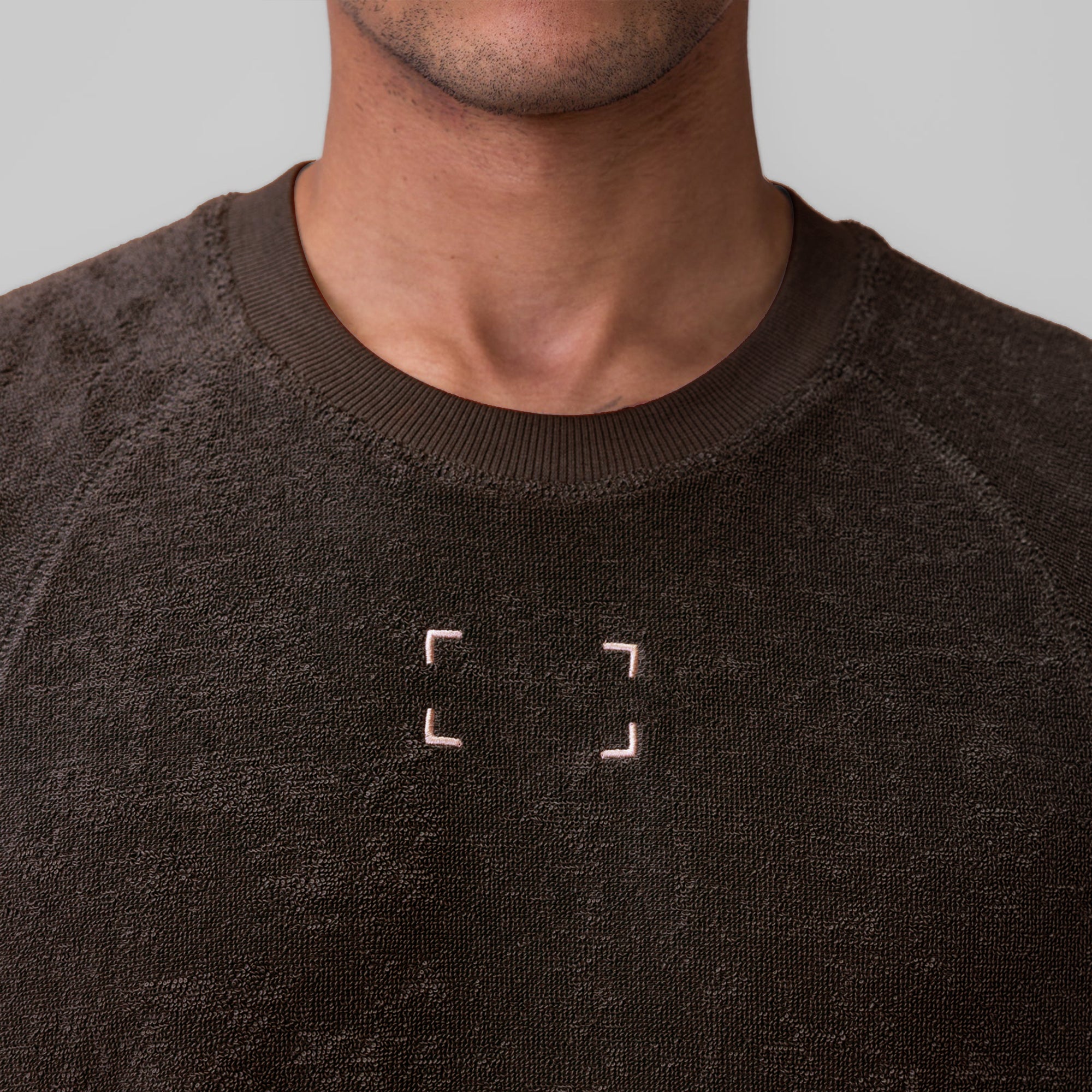 Towel Terry Cutoff in Dark Earth worn by model, front view showing embroidered logo detail