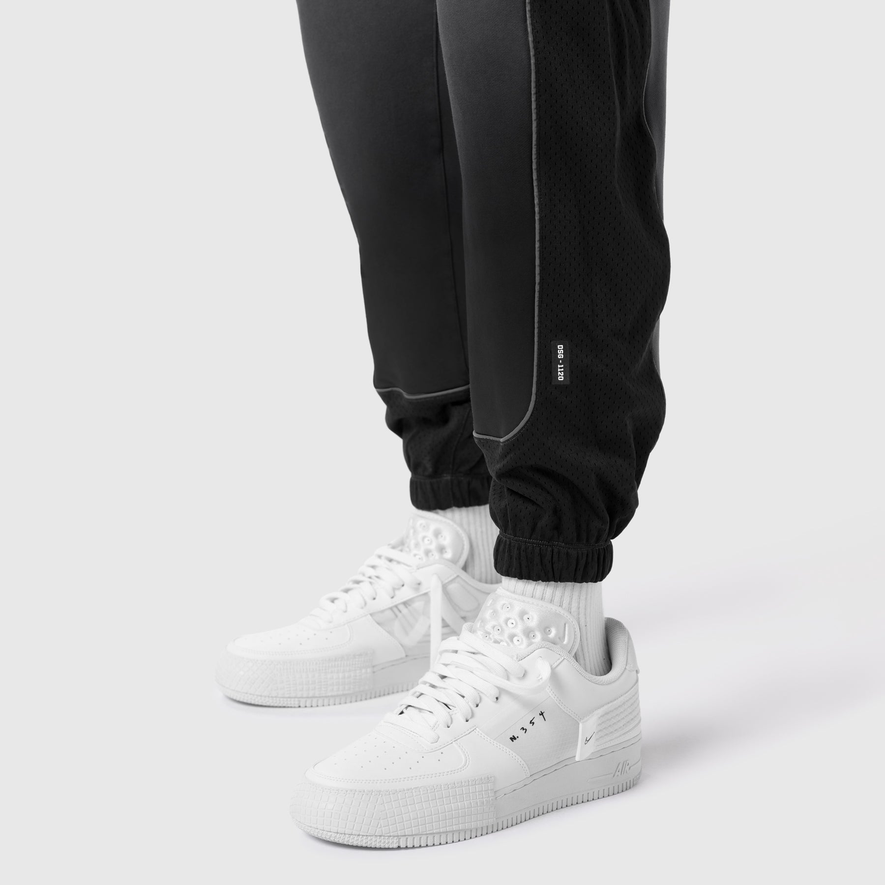 Black Tech-Terry Mesh Panel Sweats worn with white sneakers and white socks, calf detail