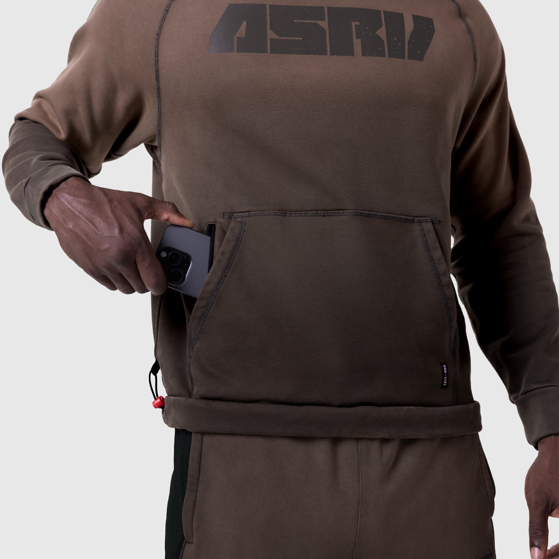 Tech-Terry Training Hoodie in dark earth, worn by model holding phone in front pocket