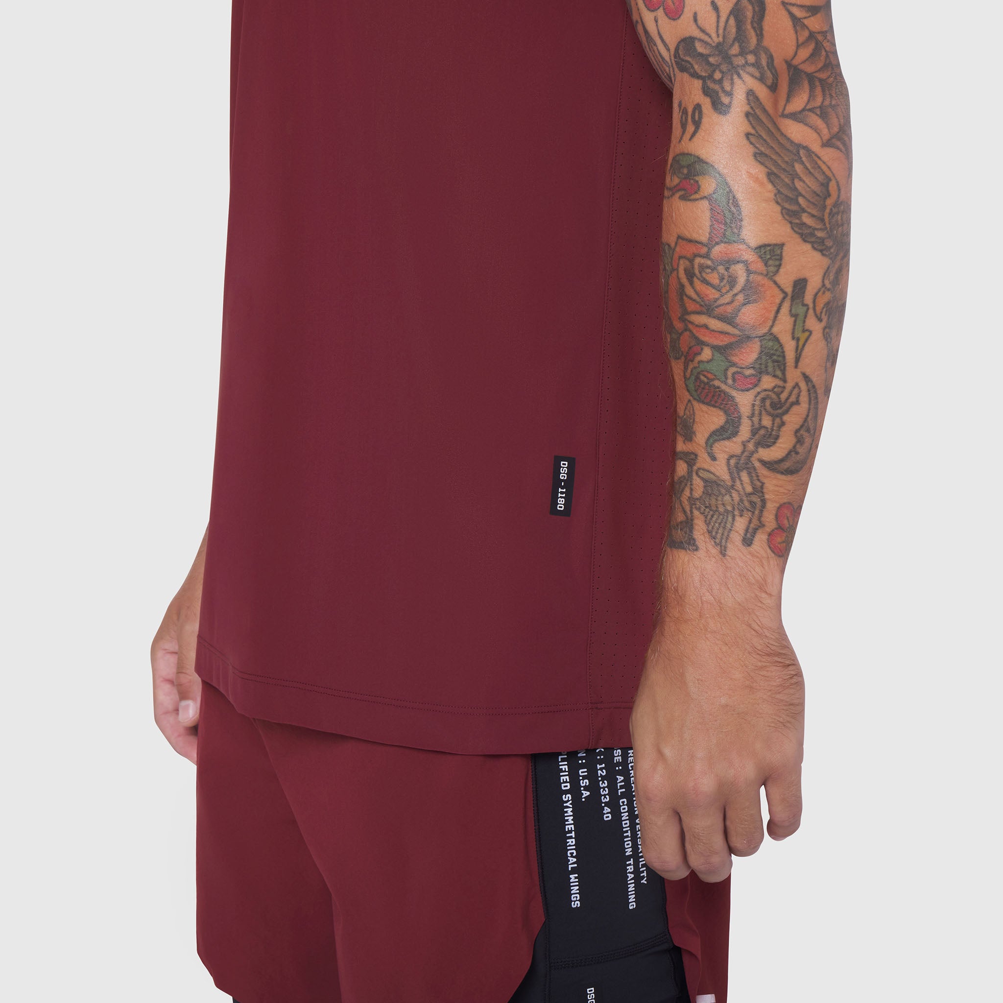 Laser-Vent Training Tee in Crimson worn by model showing side view with tattoo visible