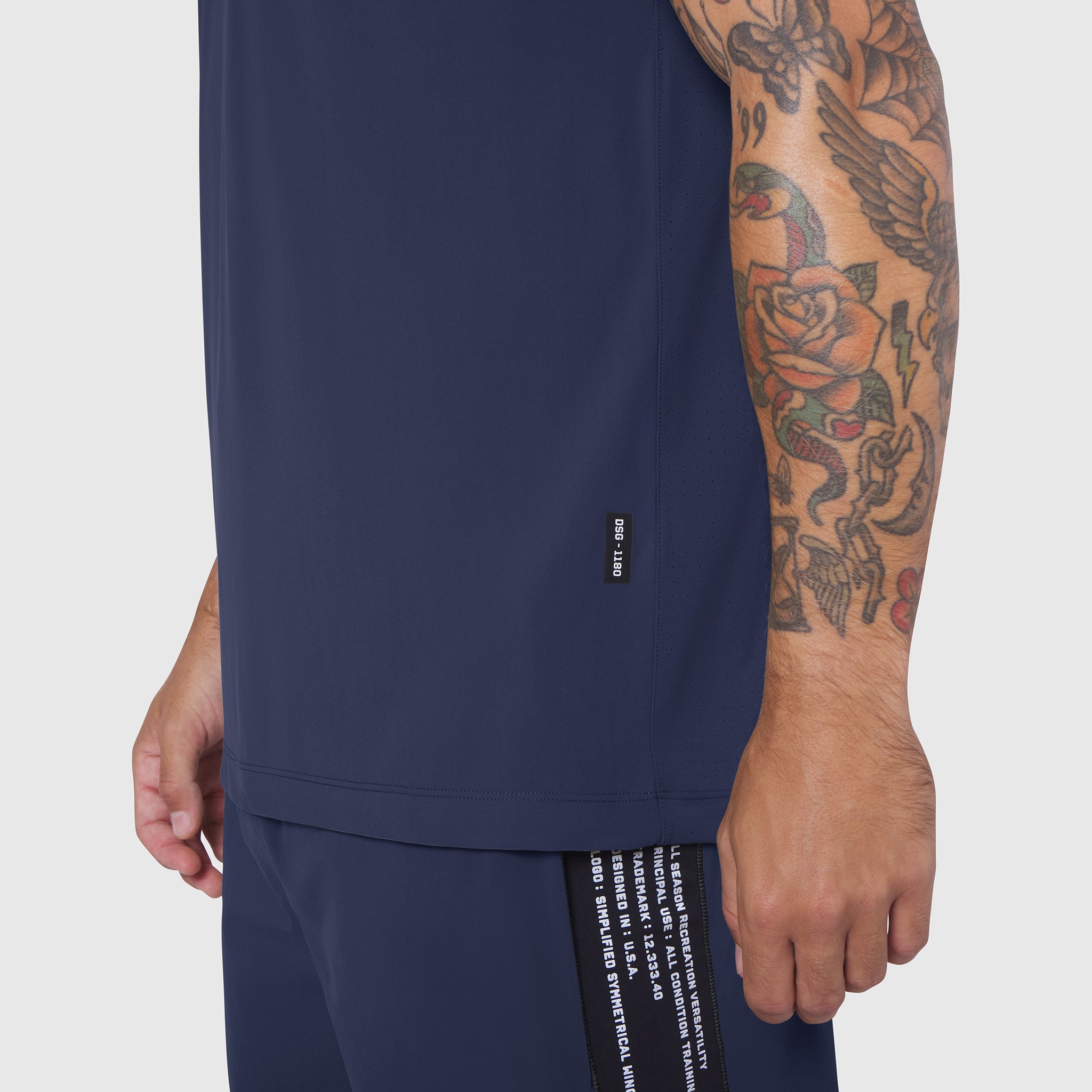 Laser-Vent Training Tee in navy worn by model showing side view with tattooed arm