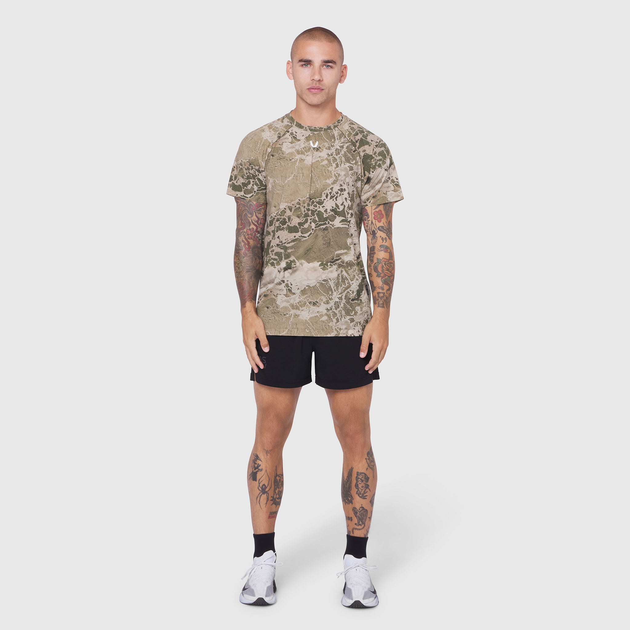Laser-Vent Training Tee in tan camo, worn by model with black shorts, front view