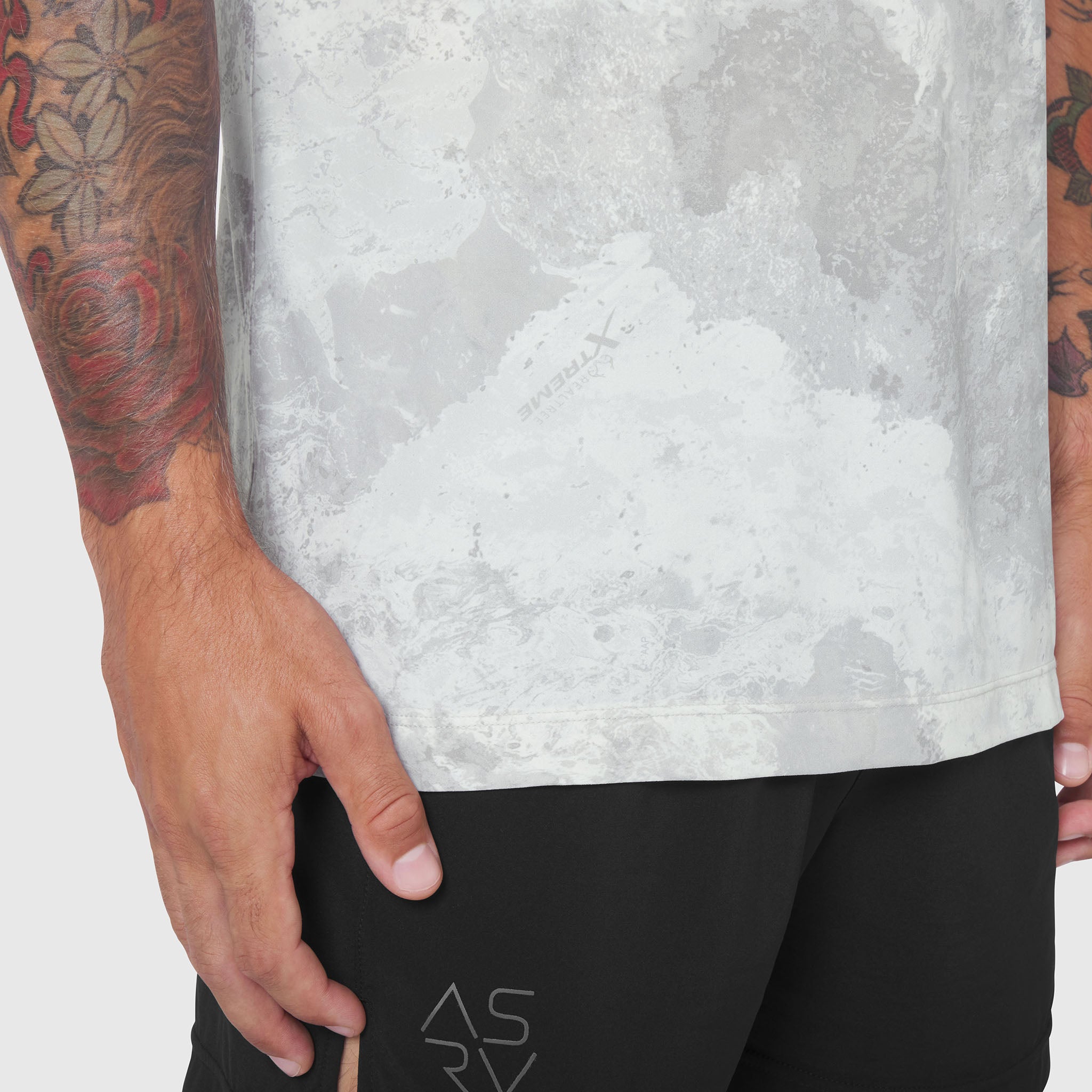 Laser-Vent Training Tee in white tie-dye, worn by model with tattooed arm, side view