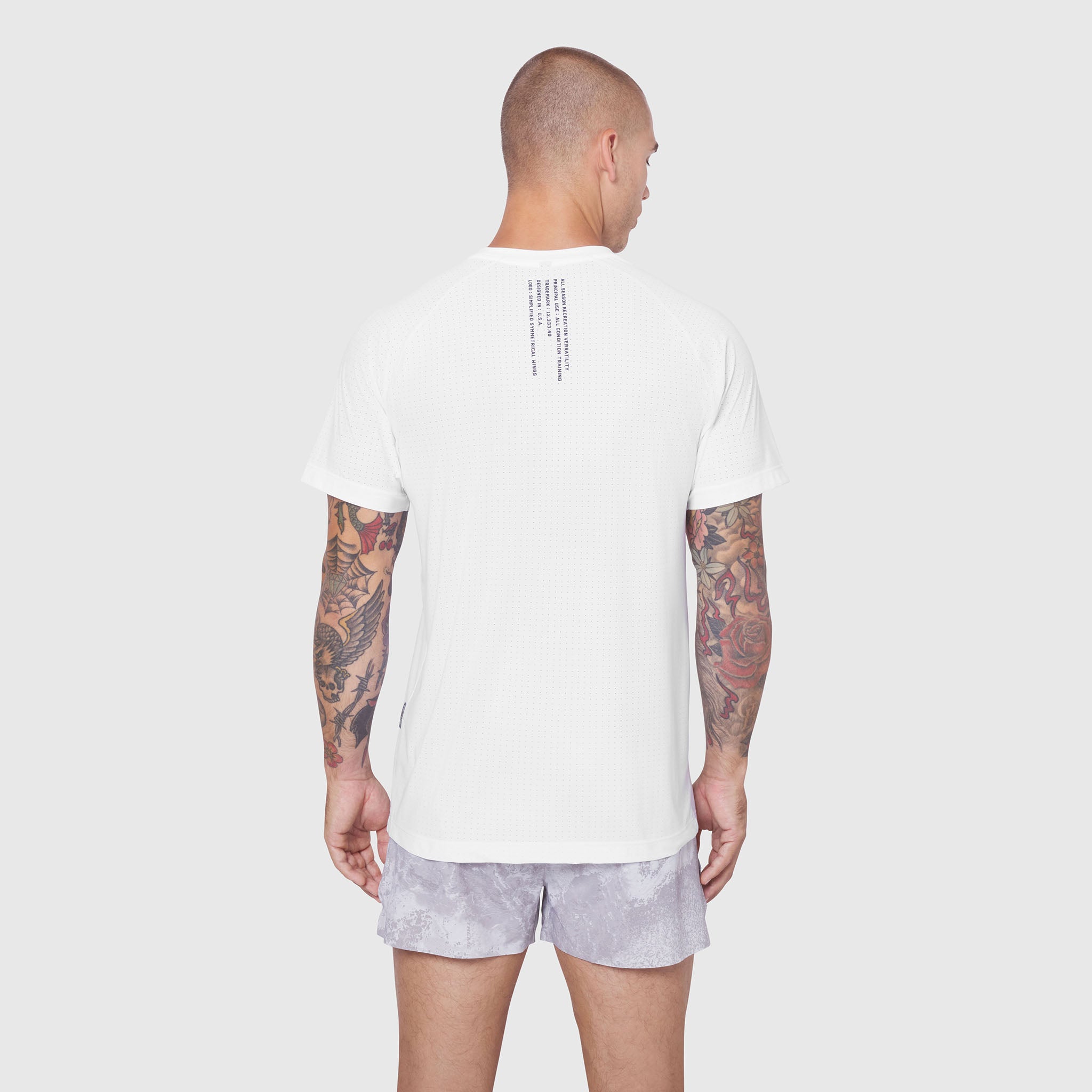 White Laser-Vent Training Tee worn by model from back view, showing textured fabric and rear design detail