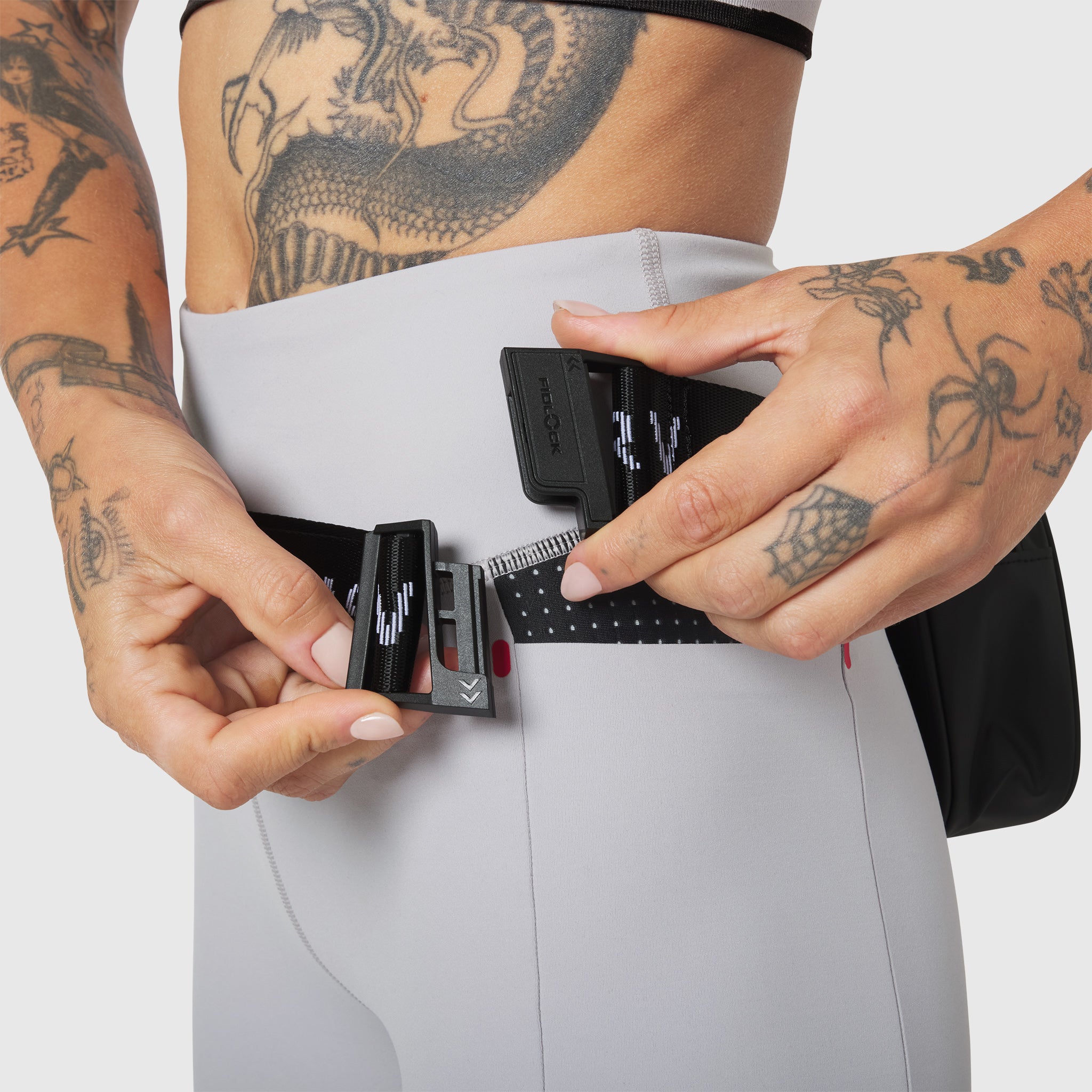 Trail Pack in Black, worn on model's waist, front view