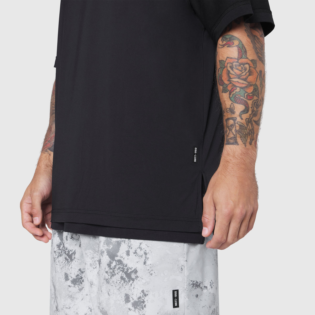 Black Supima Ice-Skin Reversible Tee worn by model showing side view with tattoos visible