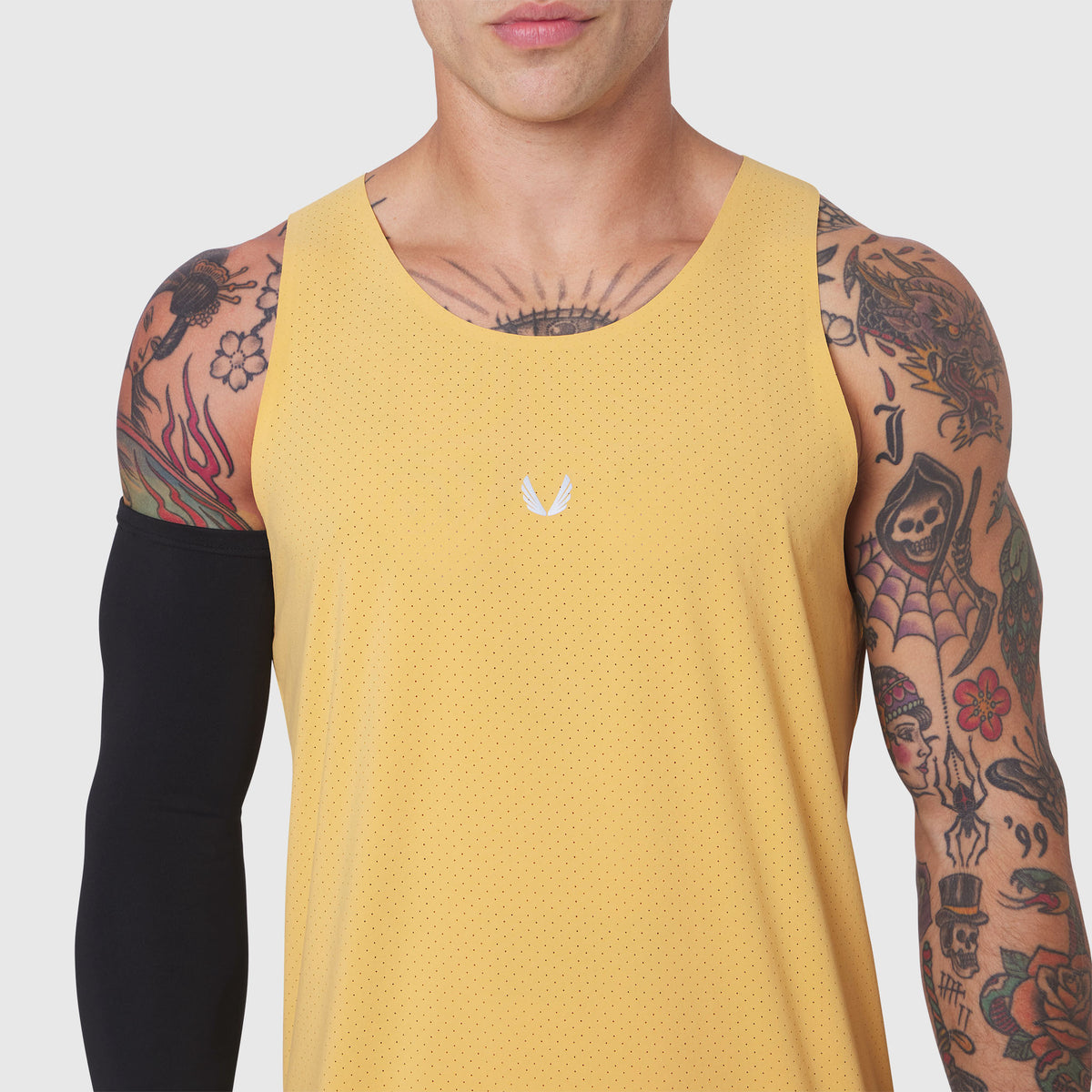 Aerotex Perforated Run Tank in amber yellow worn by tattooed model, front view