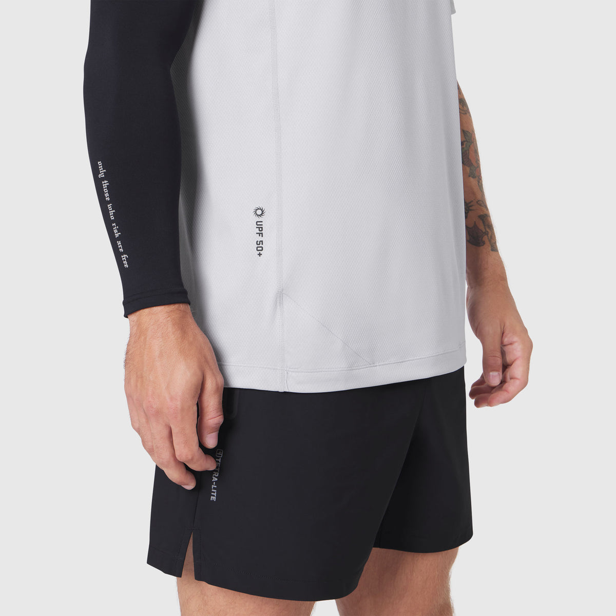 AEROSILVER UPF50+ Run Tee in white, worn by model with black shorts, side view