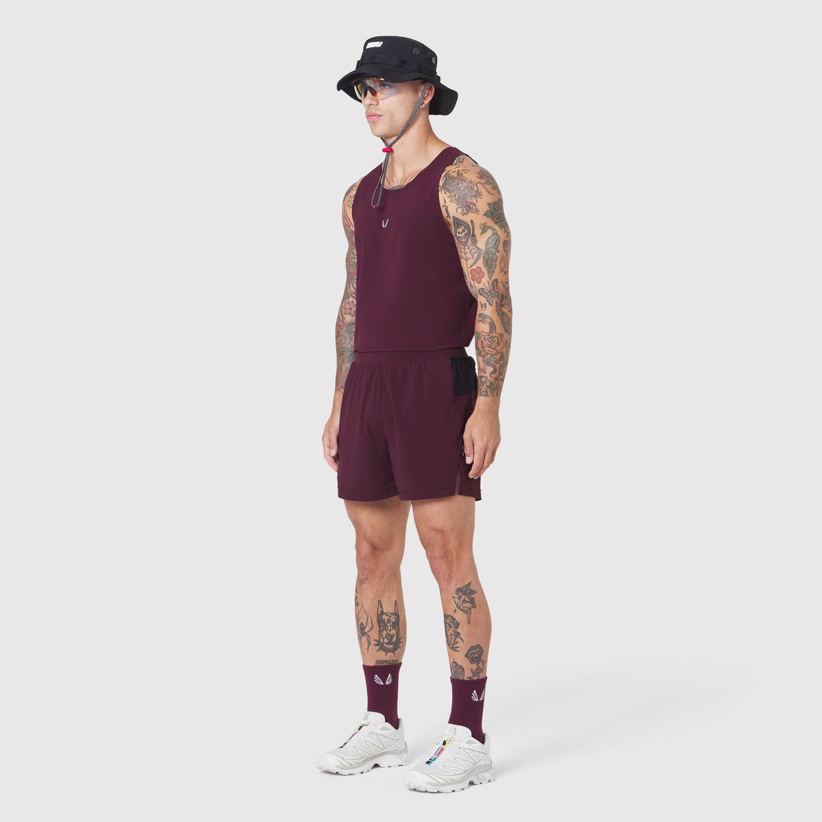 Aerotex Distance Run Short in merlot, modeled with matching socks and white sneakers