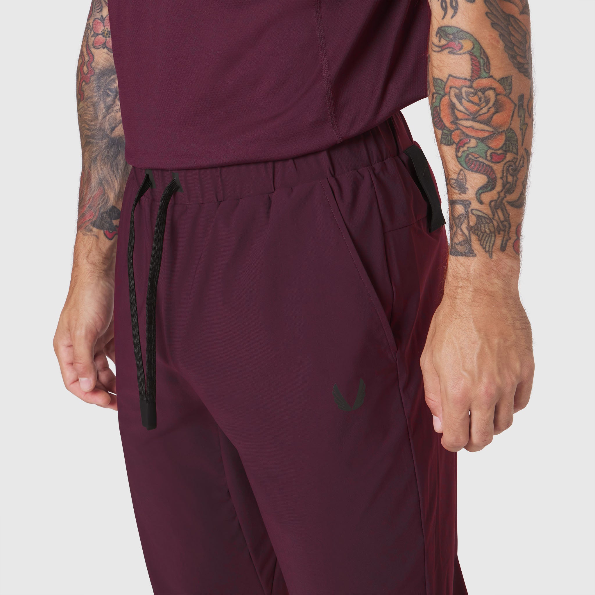 TETRA-LITE Training Jogger in merlot worn by model, side view detail of pocket and drawstring
