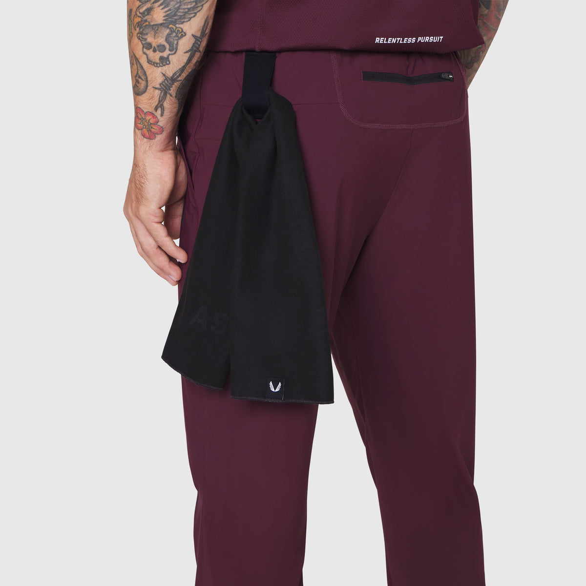 TETRA-LITE Training Jogger in merlot worn by model, side view with black towel