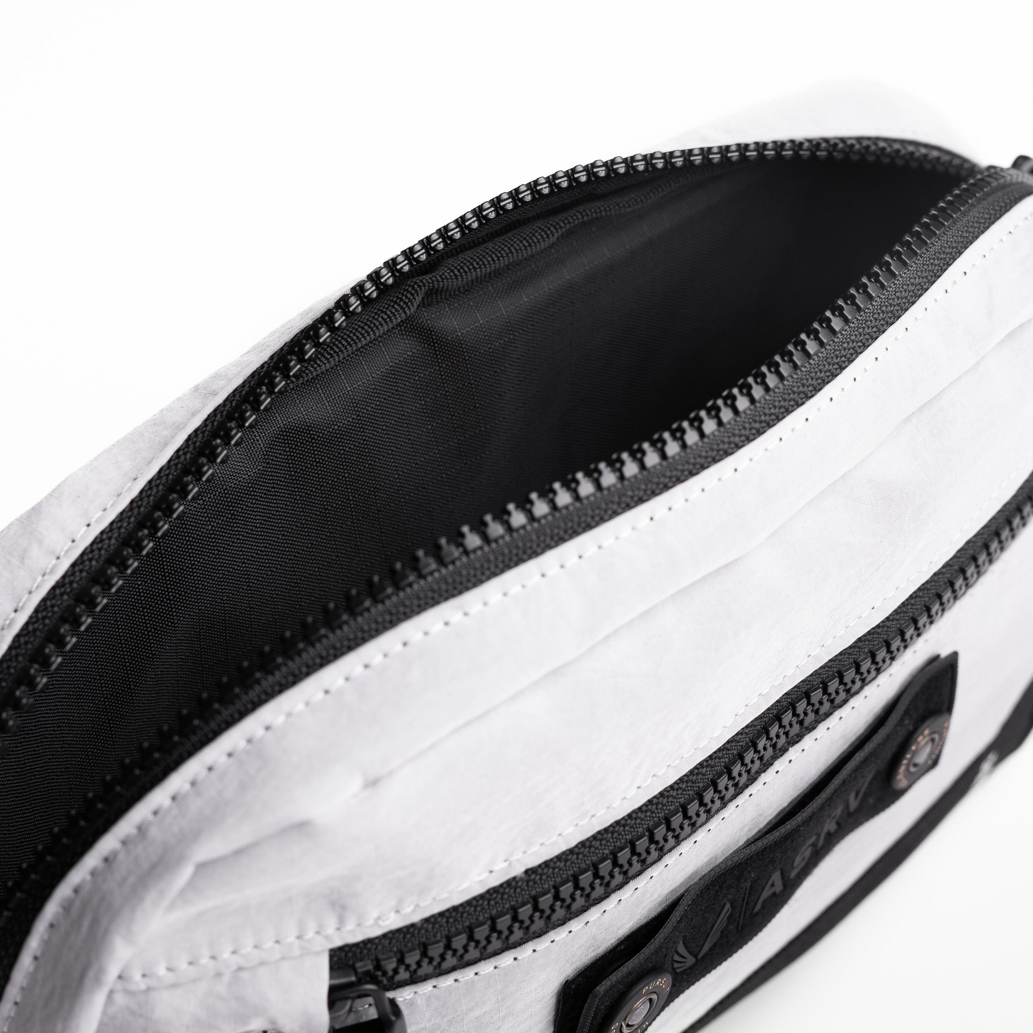 Flatlay 1231 Ripstop Crossbody Bag in white and black, open view showing interior