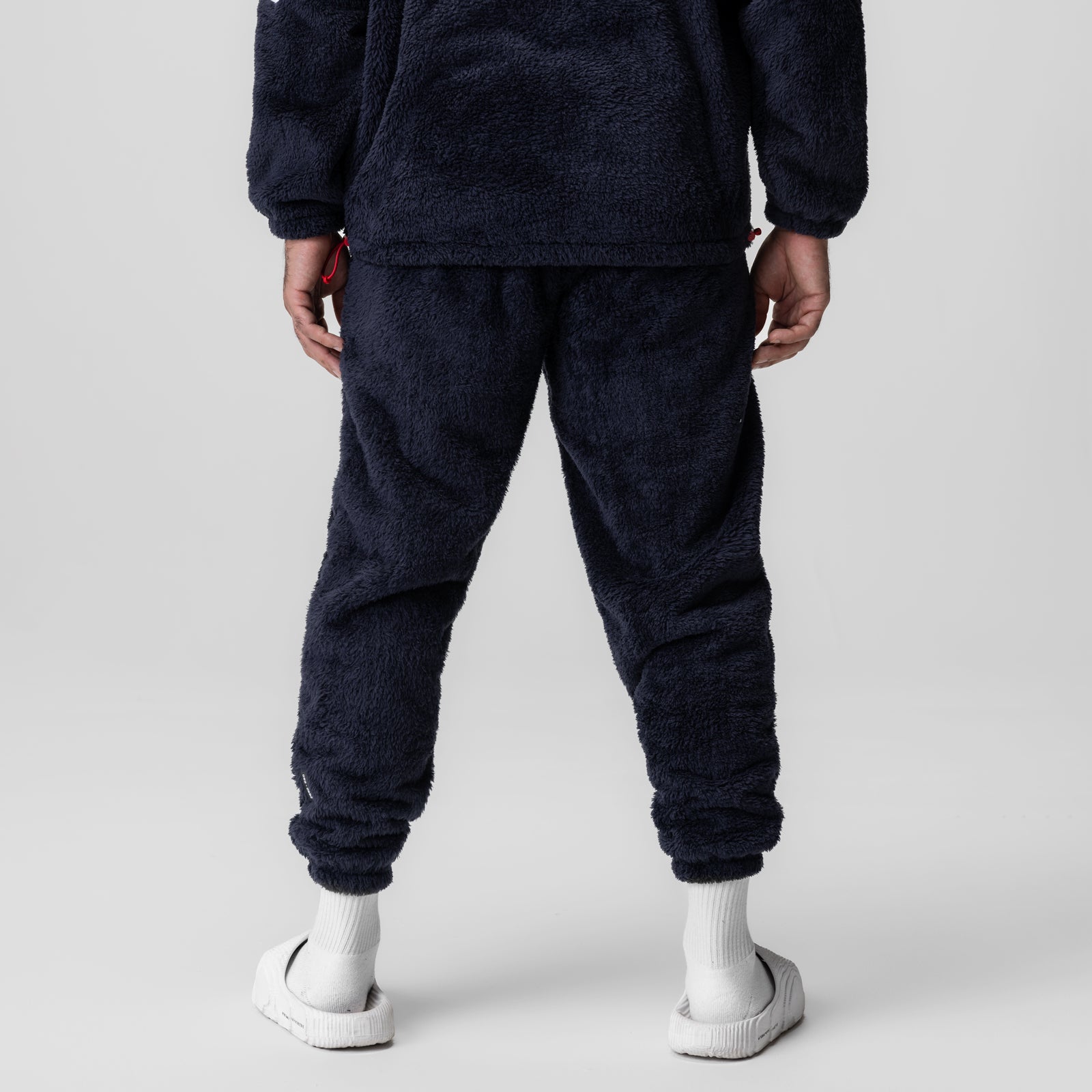 Sherpa Recovery Sweats in navy worn by model, back view with white socks