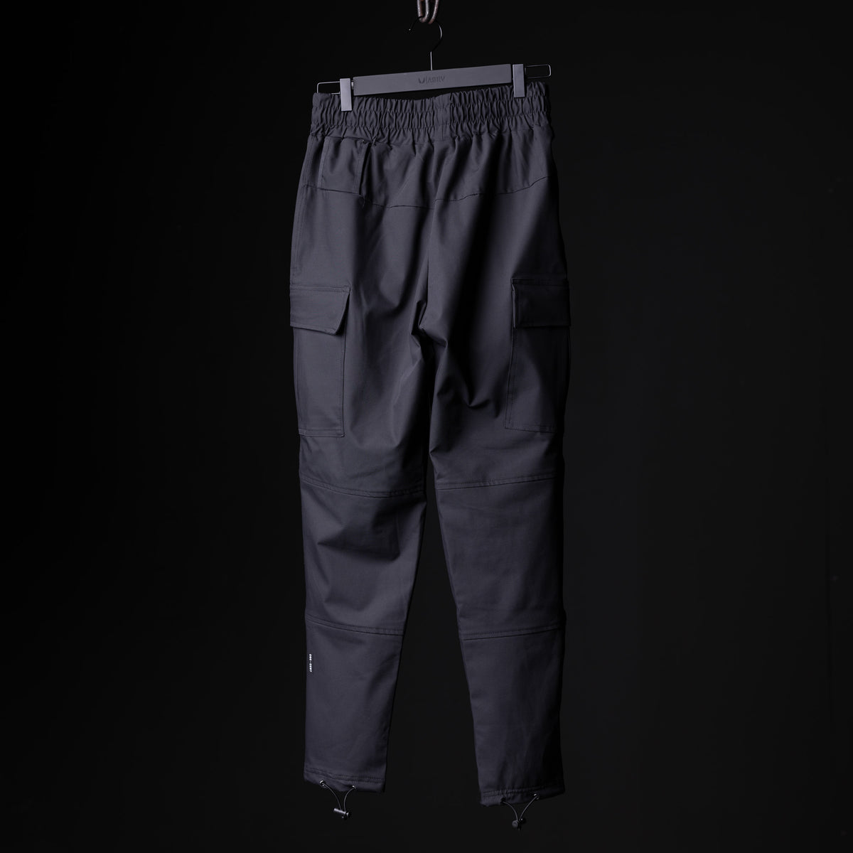 SP'20 Cargo Track Pant in charcoal gray, displayed on hanger against black background