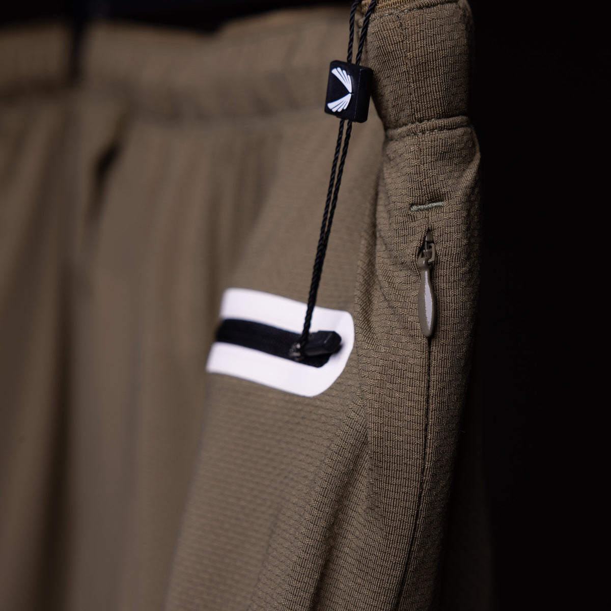 SP'19 7" Linerless Short in khaki, detail shot of drawcord and pocket