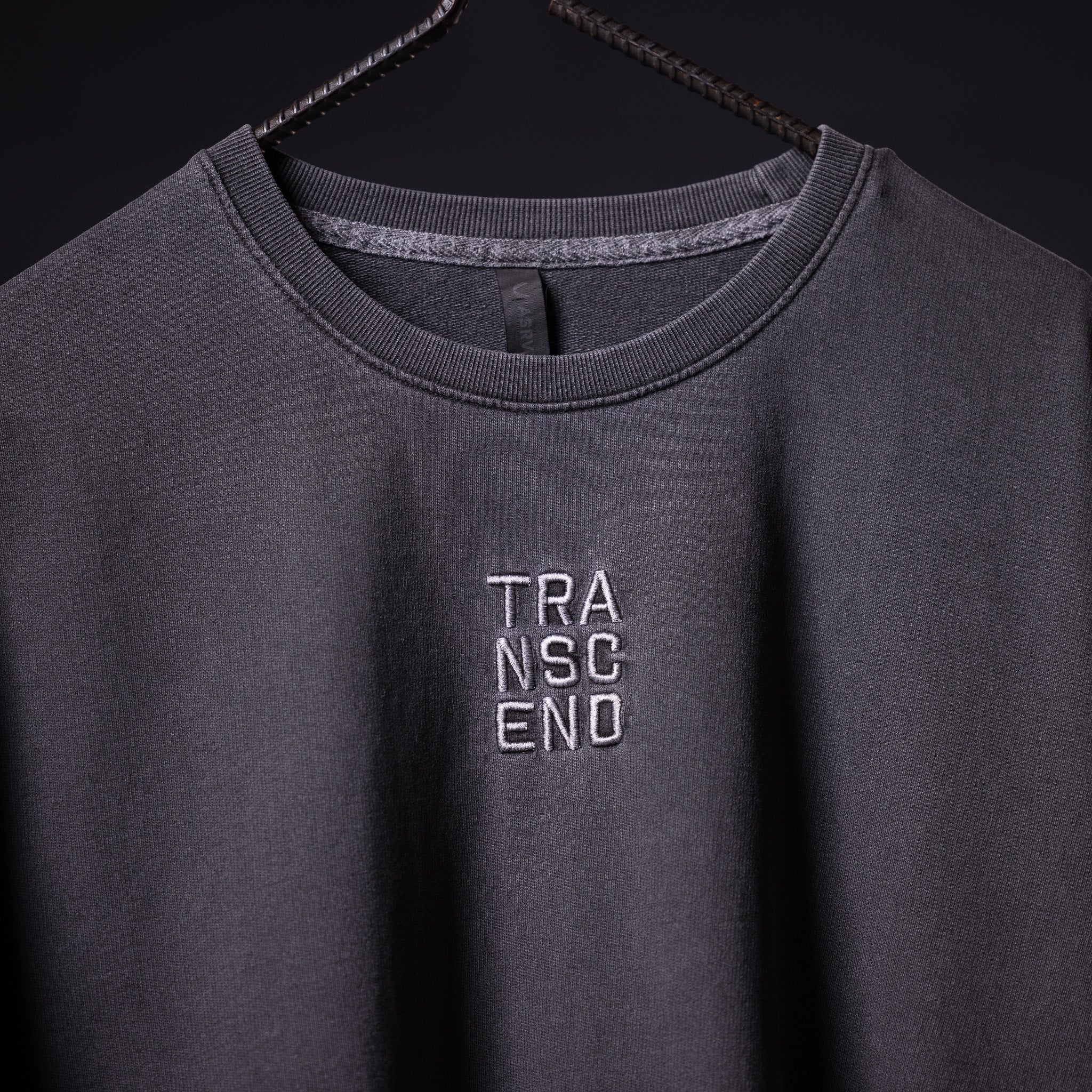 SP'22 Stone Washed Oversized Tee in charcoal gray on hanger, front view with TRANSCEND embroidery