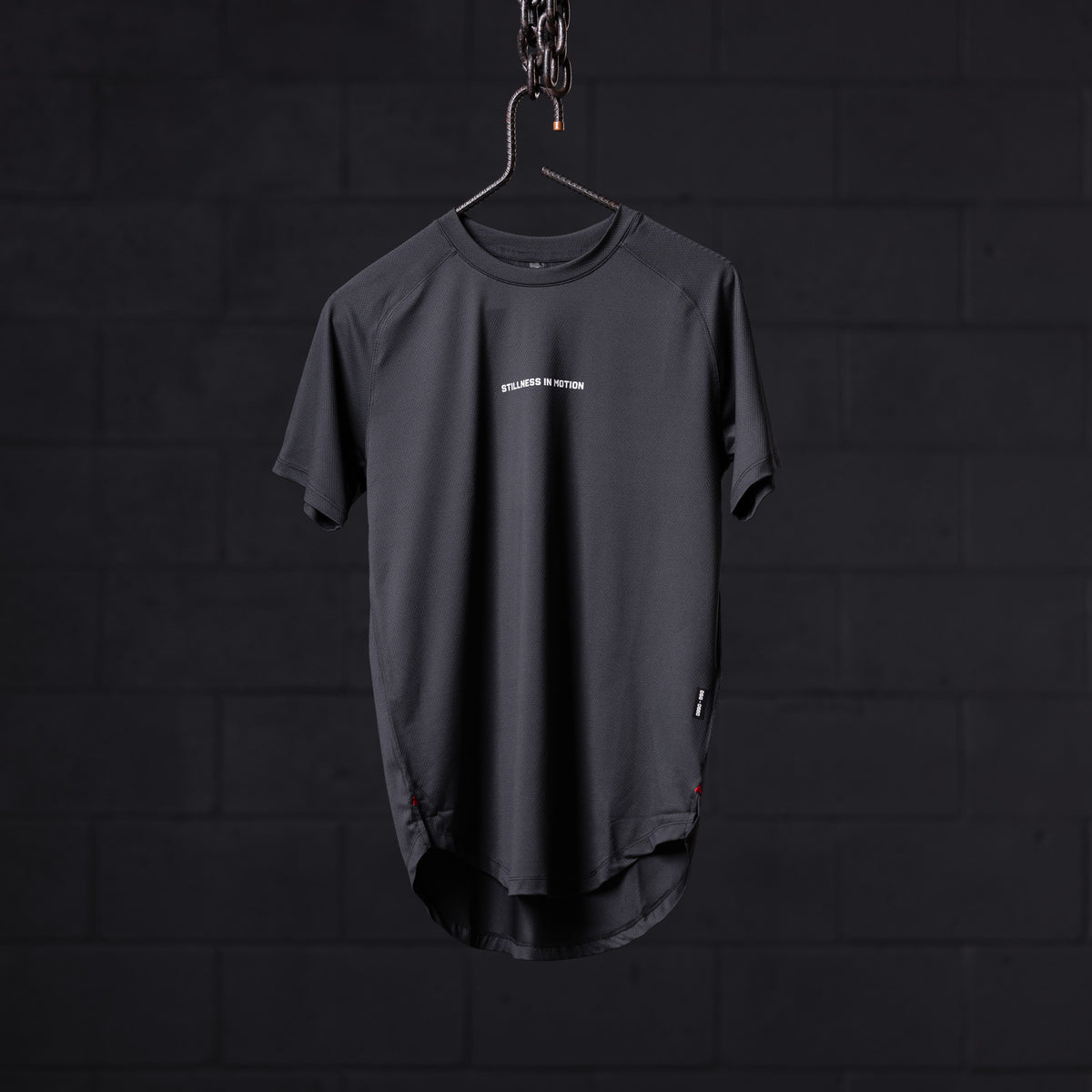 SM'22 Established Tee in charcoal gray, displayed on hanger against dark background