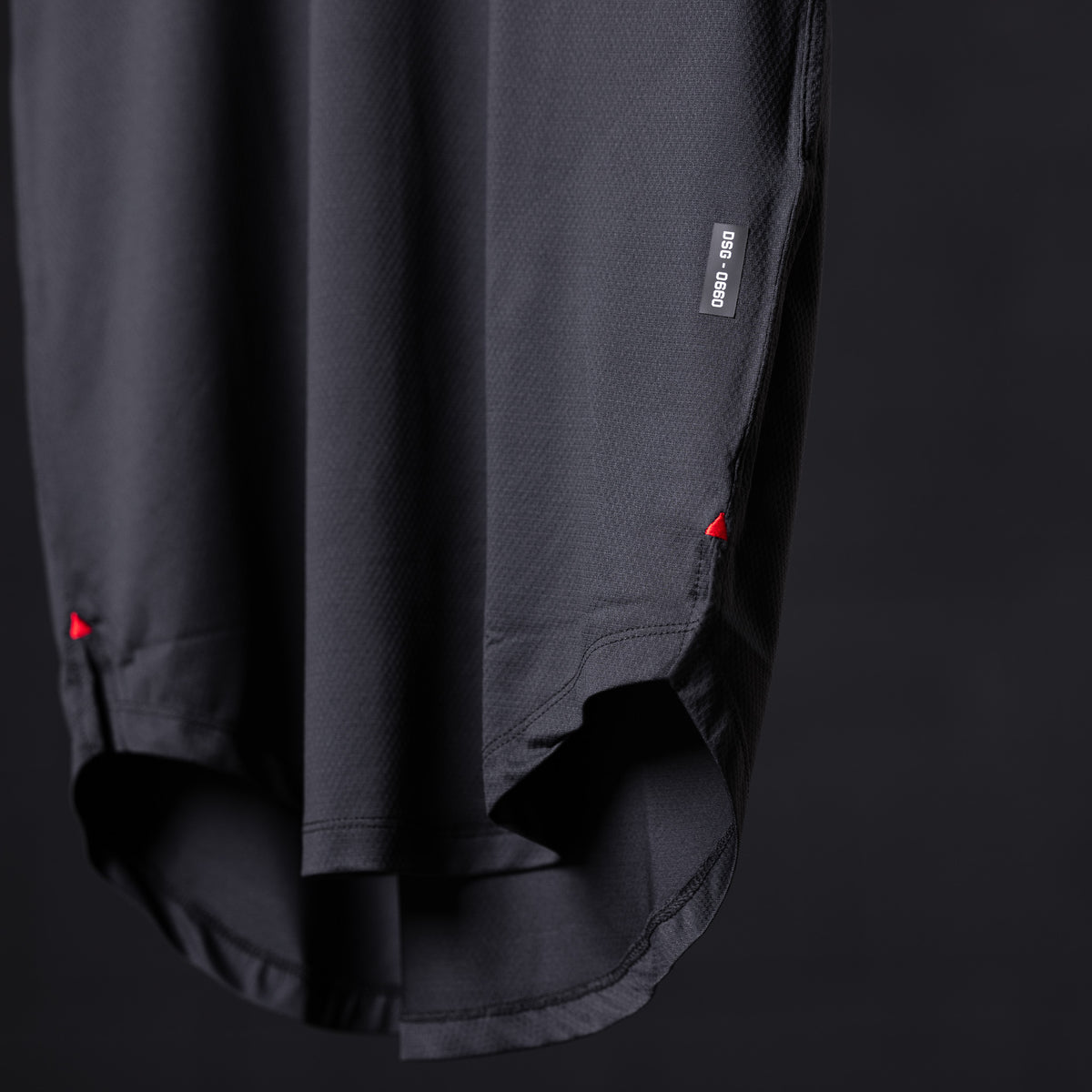 SM'22 Established Tee in charcoal, detail shot of hem and side seam with red accent