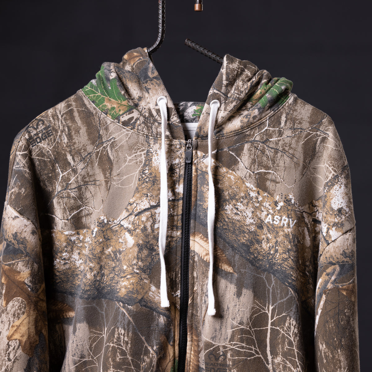 Distressed Warmup Zip Hoodie in tan camo with white drawstrings, front view on hanger