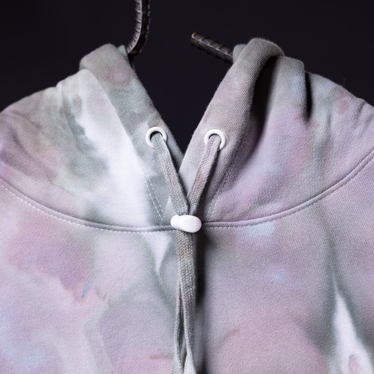 SM'22 Tie Dye Hoodie in lavender and white tie dye, front detail closeup showing drawstring and hood