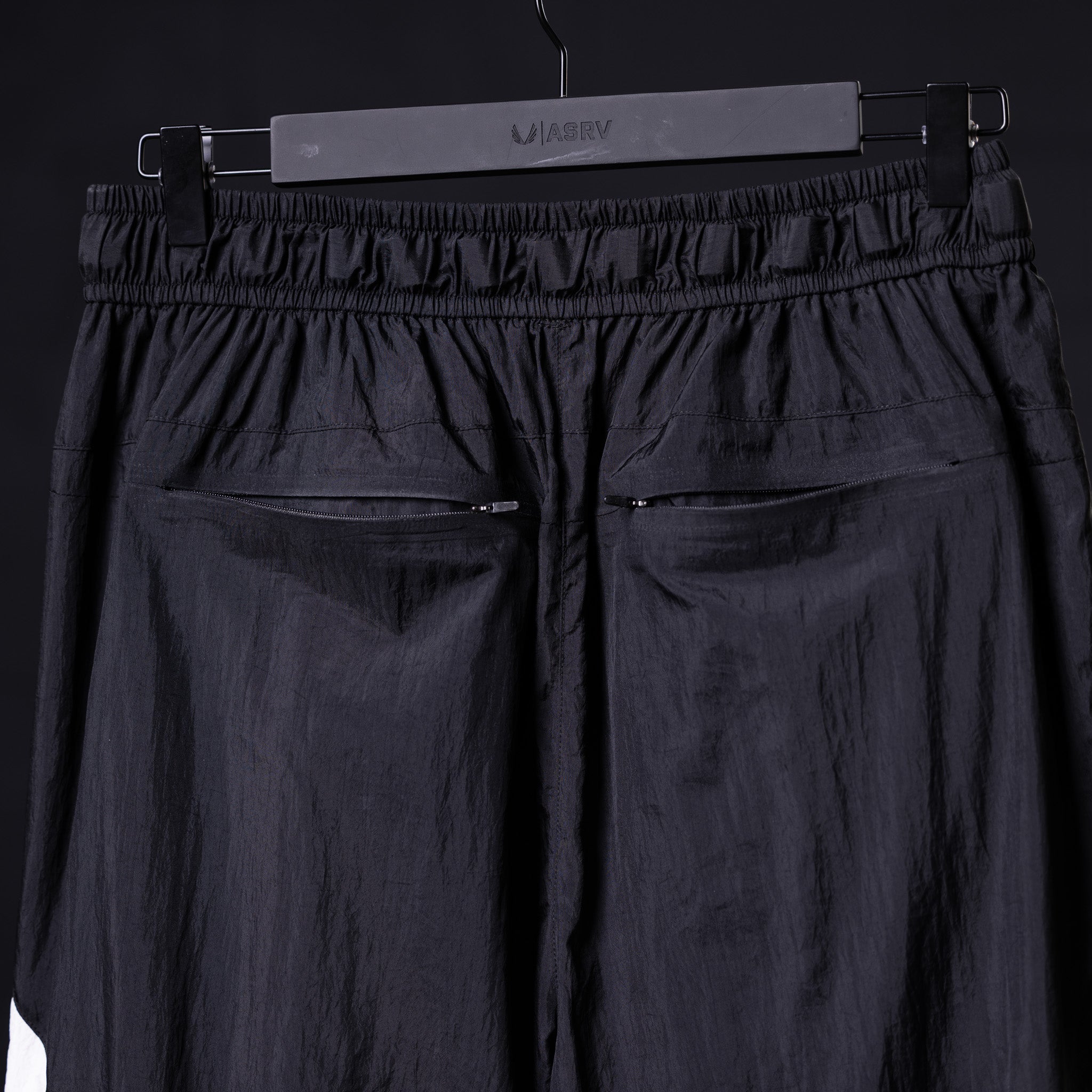 Flatlay of 2021 Oversized Track Pant in navy, back view on hanger