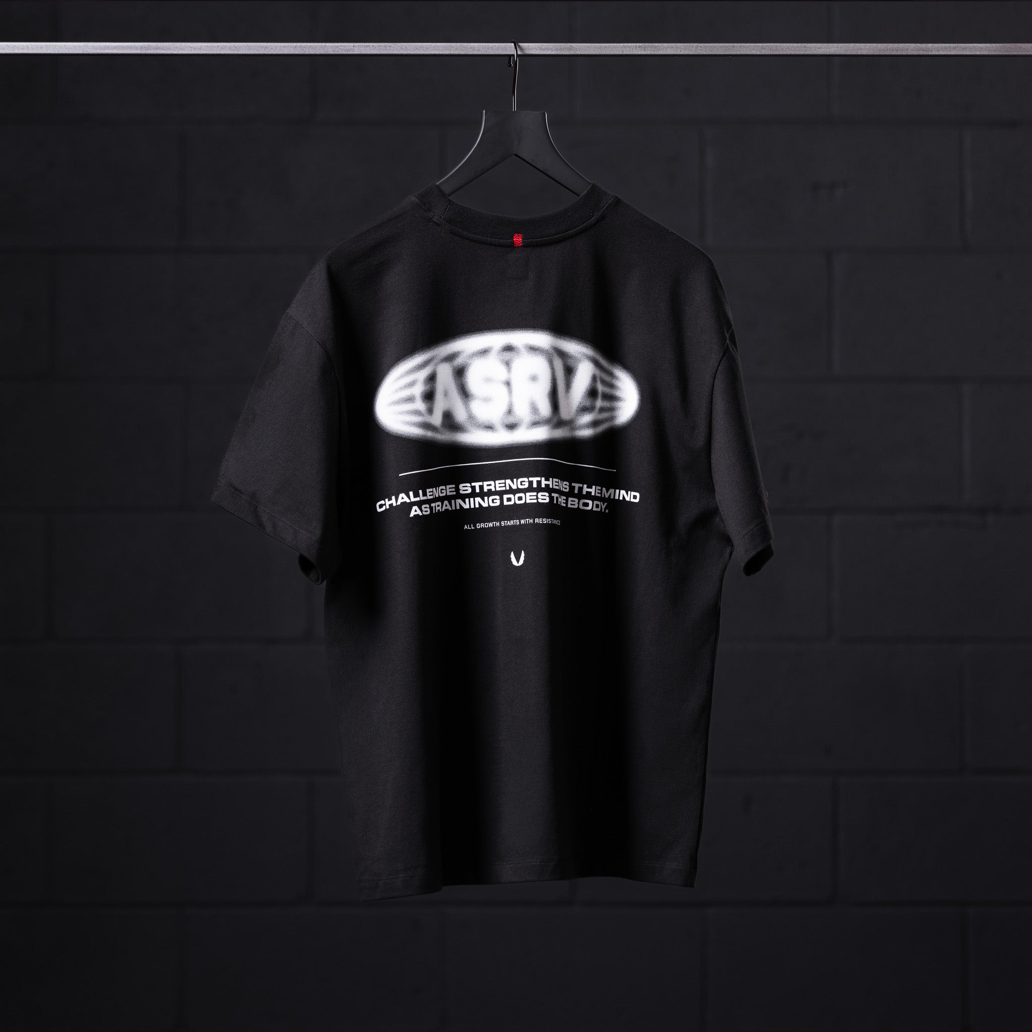 Black Tech Essential Relaxed Tee with 'Global Reach' graphic design on hanger