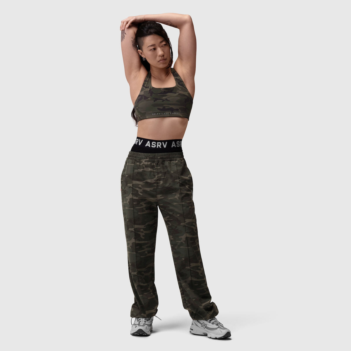 W036 Ripstop Relaxed Track Pant in dark camo, worn by model with matching sports bra