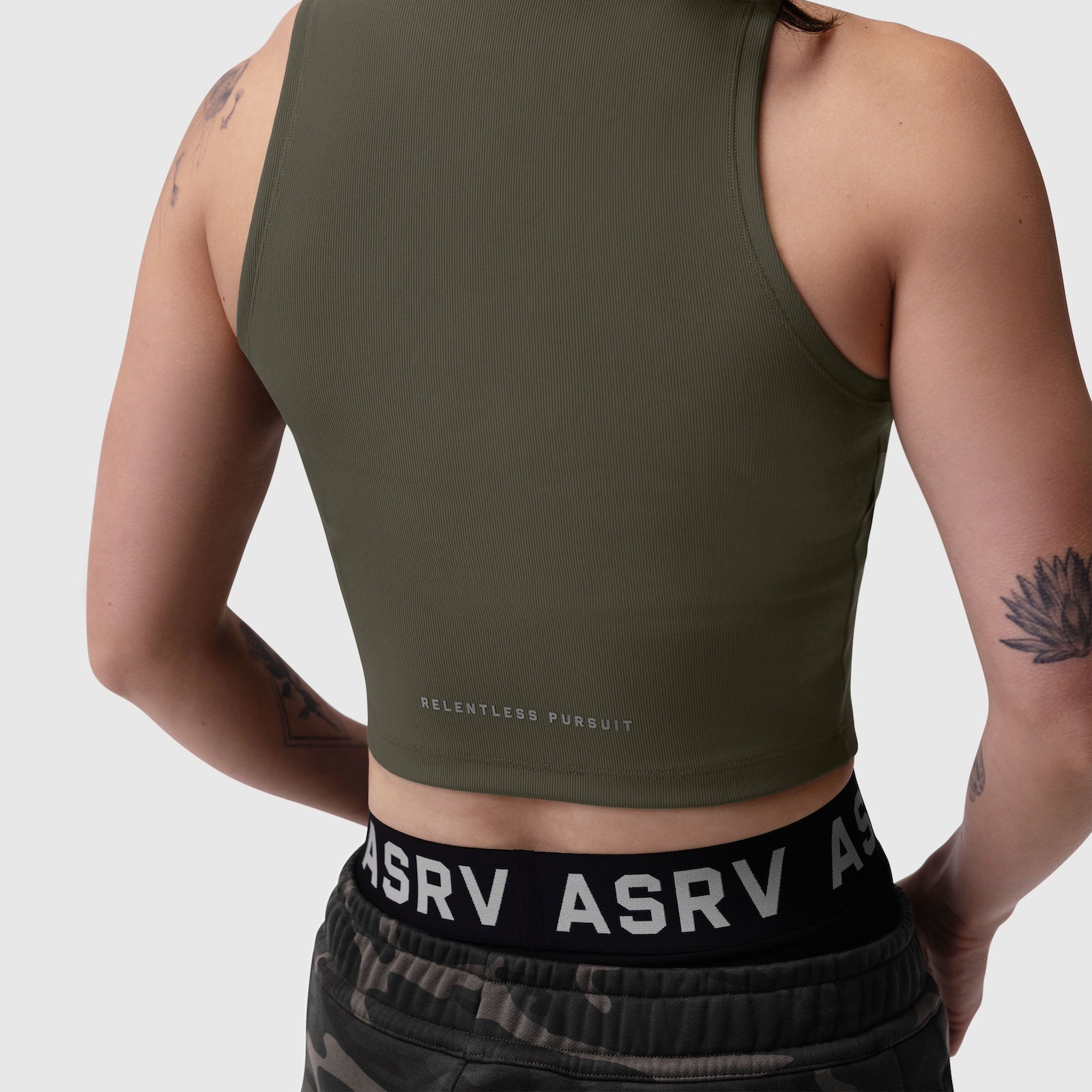 Olive ribbed mockneck tank worn by model, back view showing 'Relentless Pursuit' text