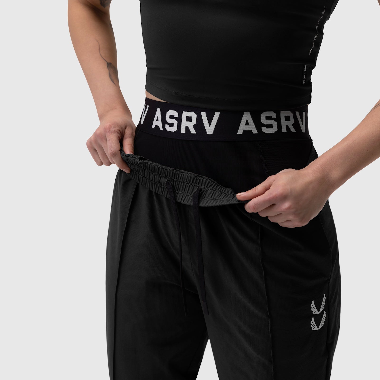 Black ripstop relaxed track pant worn by model, showing waistband detail with ASRV branding