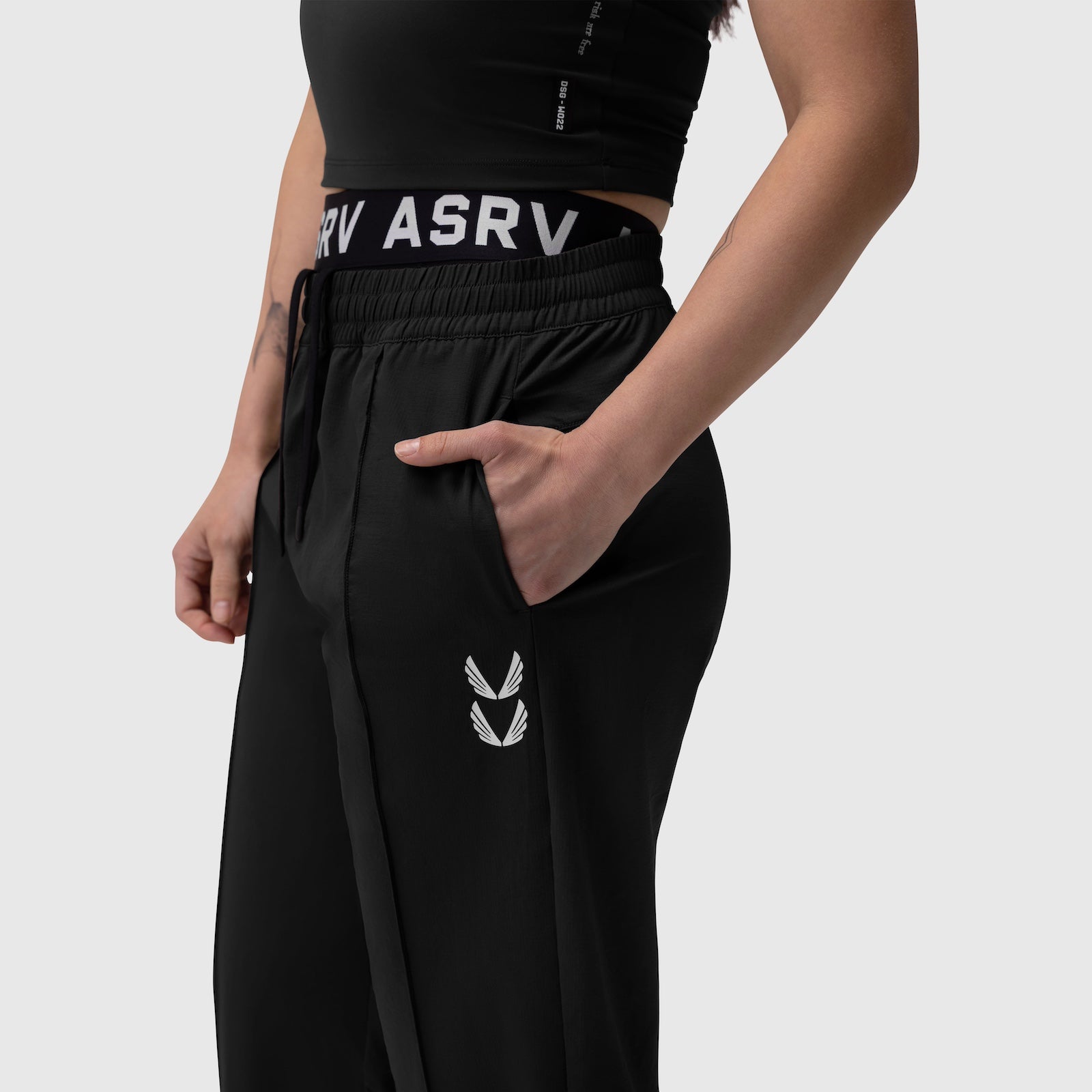 W036 Ripstop Relaxed Track Pant in black, worn by model showing side view with hand in pocket