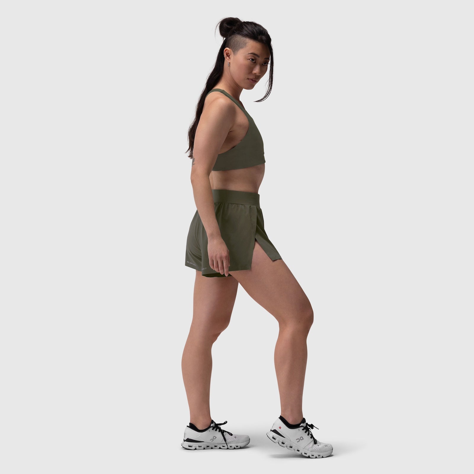 Aerotex Side Split Run Short in olive, worn by model in side profile stance