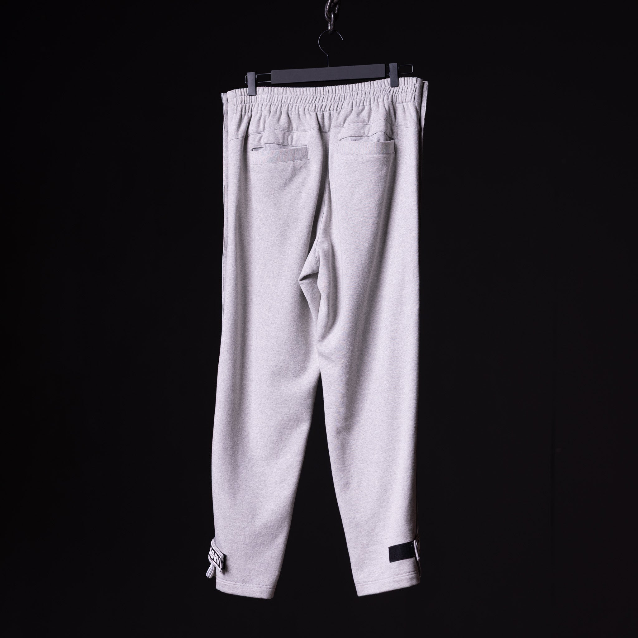 SP'22 Tearaway Jogger in light gray, displayed on hanger against black background