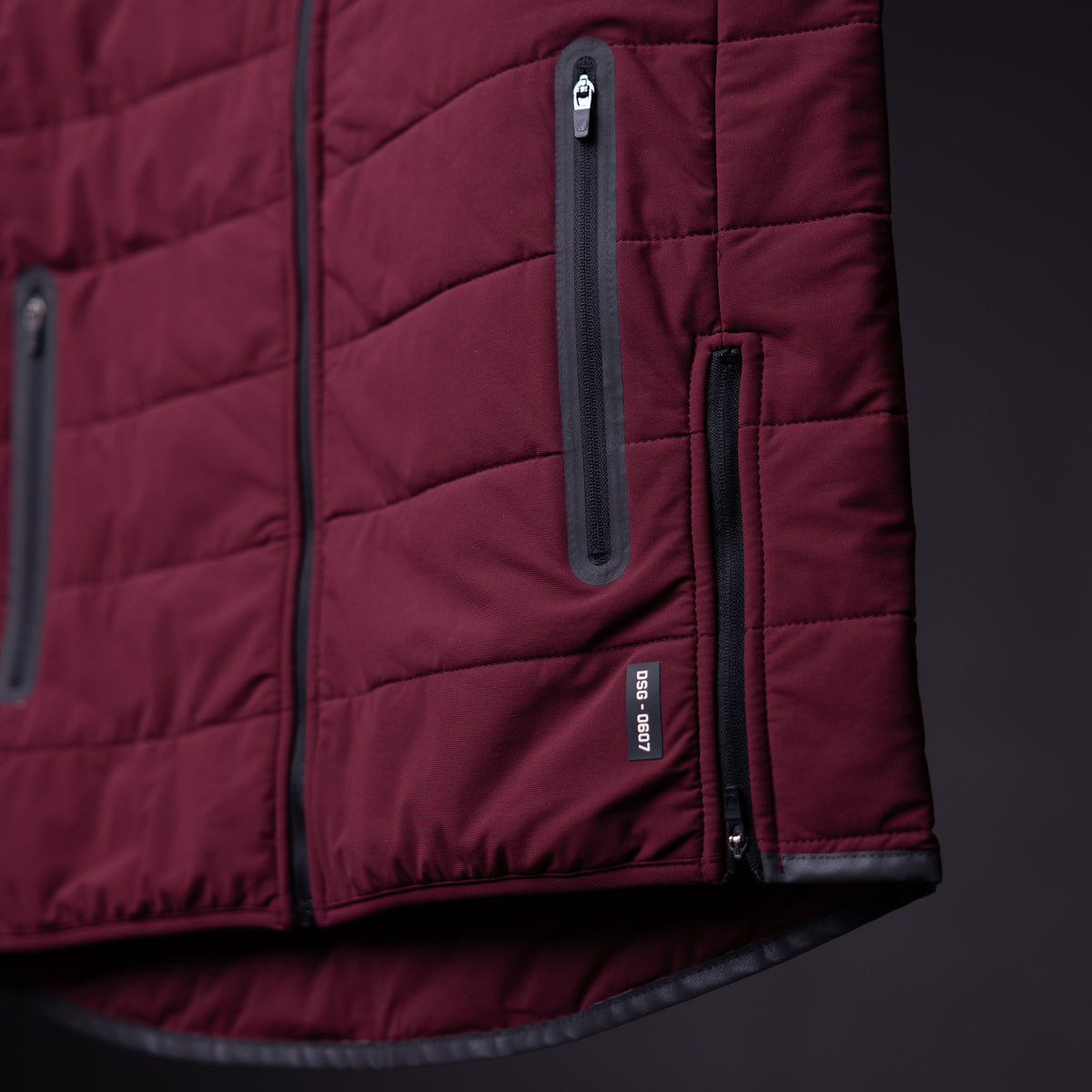 FA'22 Adventure Vest in burgundy, detail shot showing zipper pockets and quilted construction