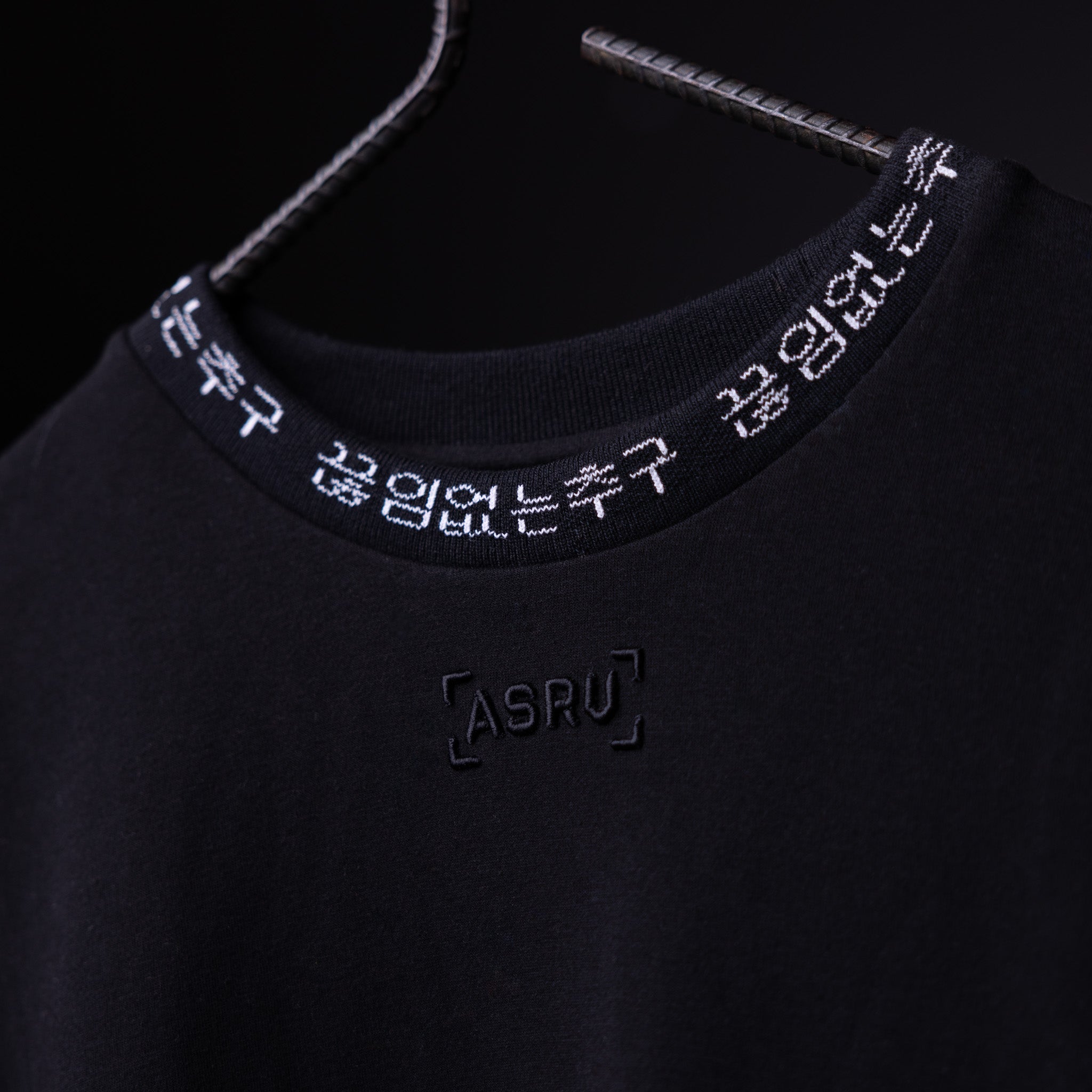 WN'20 Oversized Cinch Tee detail shot showing black neckline with white embroidered branding and Korean text