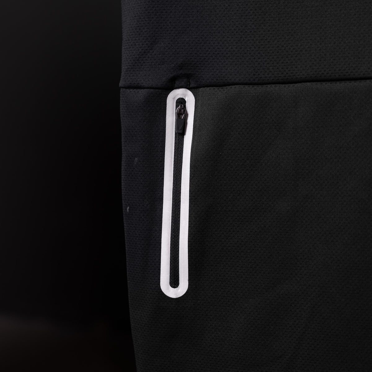 SP'20 Mesh Utility Tank detail shot of white zippered pocket on black fabric